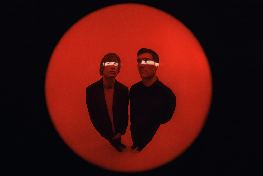 Fotografia de Bob Moses con un fondo rojo